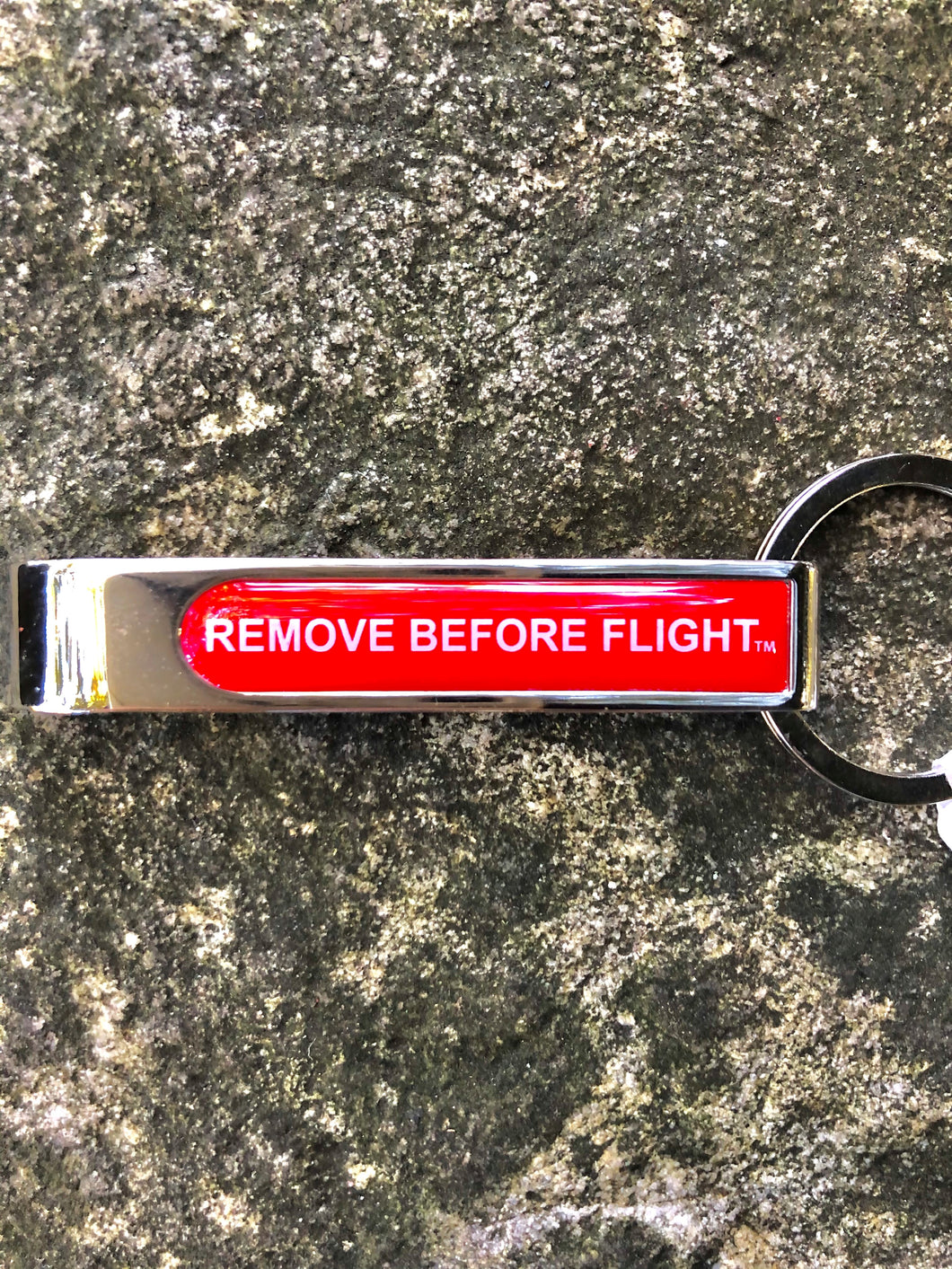 keychain with bottle opener Remove Before flight written in white.